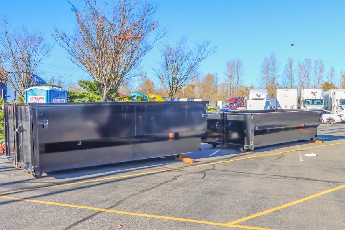 Professional dumpster rental service with roll-off container on residential driveway in Paola